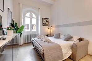 Een slaapkamer met een bed, nachtkastje en een raam met gordijnen.