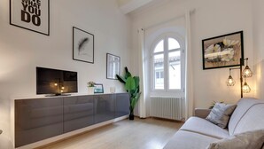Een moderne woonkamer met een bank, televisie en kunst aan de muur.