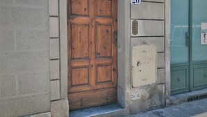 A wooden door with a number plate '20' and a utility box labeled 'CAS' on a building facade. - Mamo Florence - Zeno Apartment (Florence)
