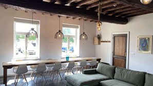 A dining area with a wooden table, chairs, a sofa, and pendant lights. - Authentic house (6p) in prime location near Maastricht (Eijsden)