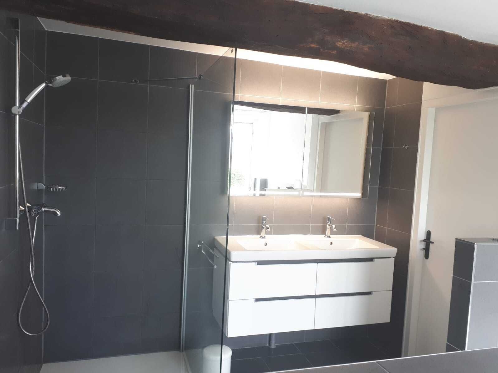 Een bad, een haardroger, handdoeken, shampoo
