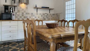 Una cocina moderna con una mesa de comedor de madera, sillas, microondas y cafetera.