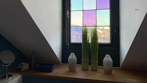 A room with a window, a mirror, and three vases on a wooden shelf. - Atmospheric apartment (5p) in toplocation near Maastricht (Eijsden)