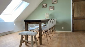 A dining area with a table and chairs, a skylight, and a wooden door. - Atmospheric apartment (5p) in toplocation near Maastricht (Eijsden)