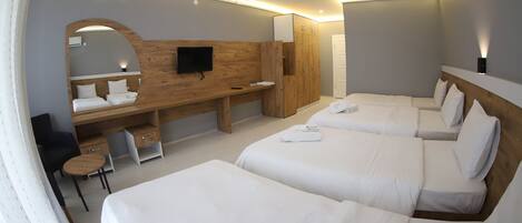 A modern hotel room with a large bed, a desk, a chair, a TV, and a wardrobe.