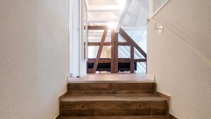 A staircase leading to an upper floor with a view of the sky through a skylight. - Hitrental Chapel Bridge Apartments (Lucerne)