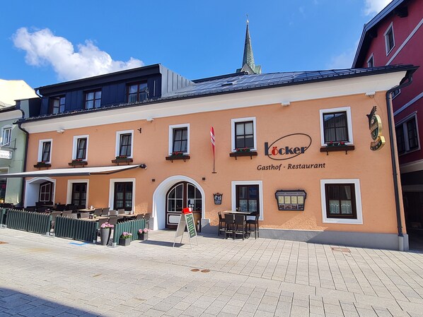 A building with a restaurant named 'Locker' on the ground floor, featuring outdoor seating with tables and chairs.