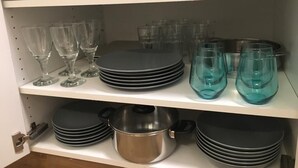 Una estantería con varios vasos y platos.