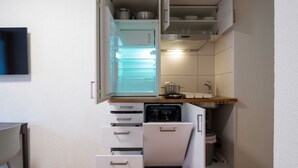 A compact kitchen with a built-in refrigerator, a dishwasher, and a sink. - Hitrental Old Town Apartments (Lucerne)