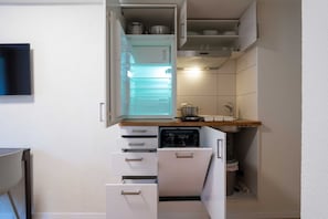 A compact kitchen with a built-in refrigerator, a dishwasher, and a sink. - Hitrental Old Town Apartments (Lucerne)