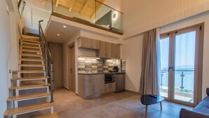 Un interior moderno con escalera, cocina y balcón.