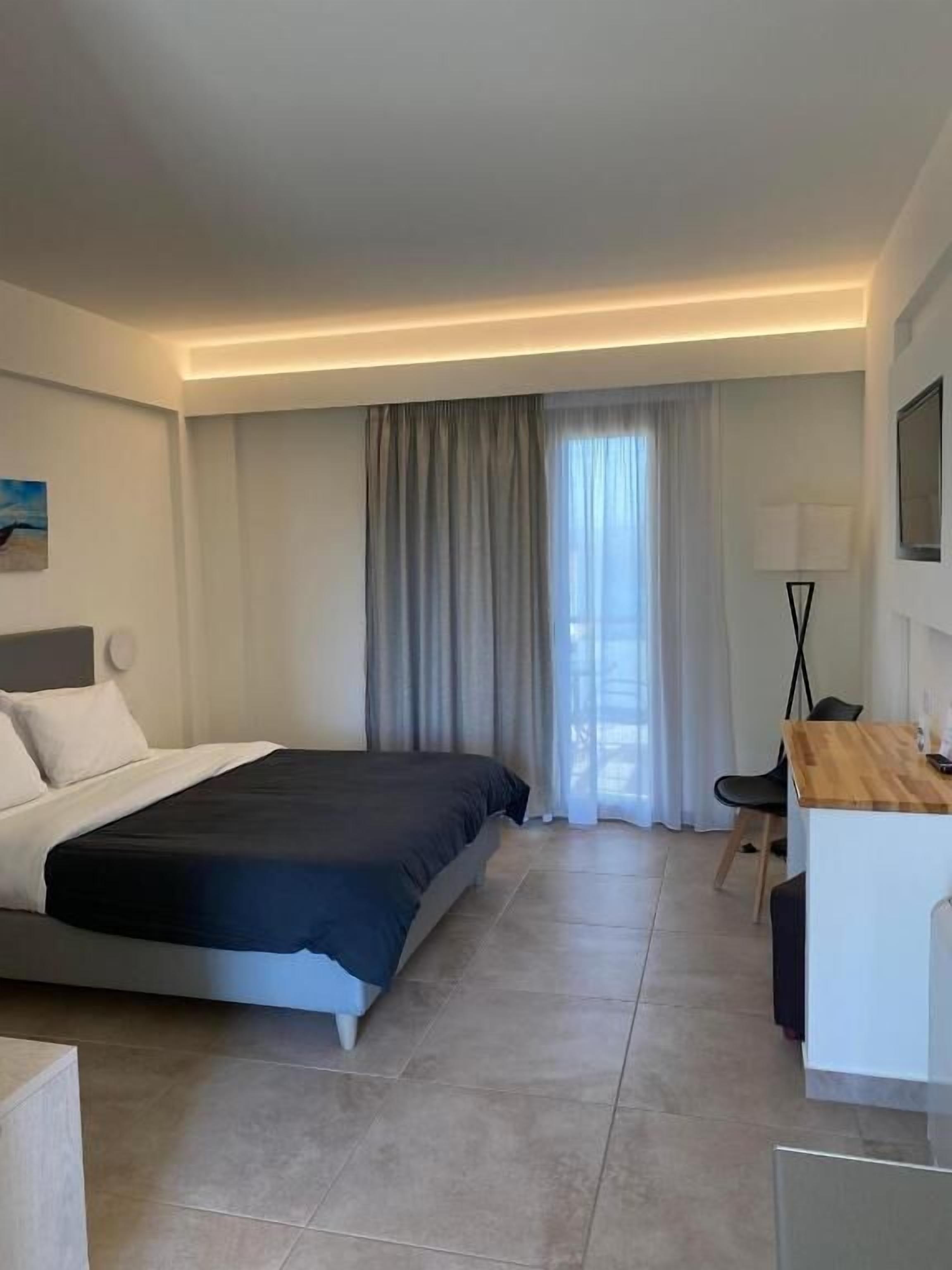 Una habitación de hotel moderna con una cama grande, un escritorio y una silla.