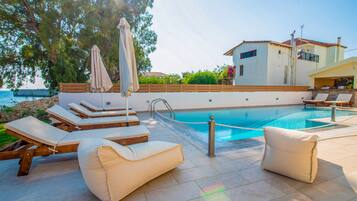 A poolside area with lounge chairs and a pool.