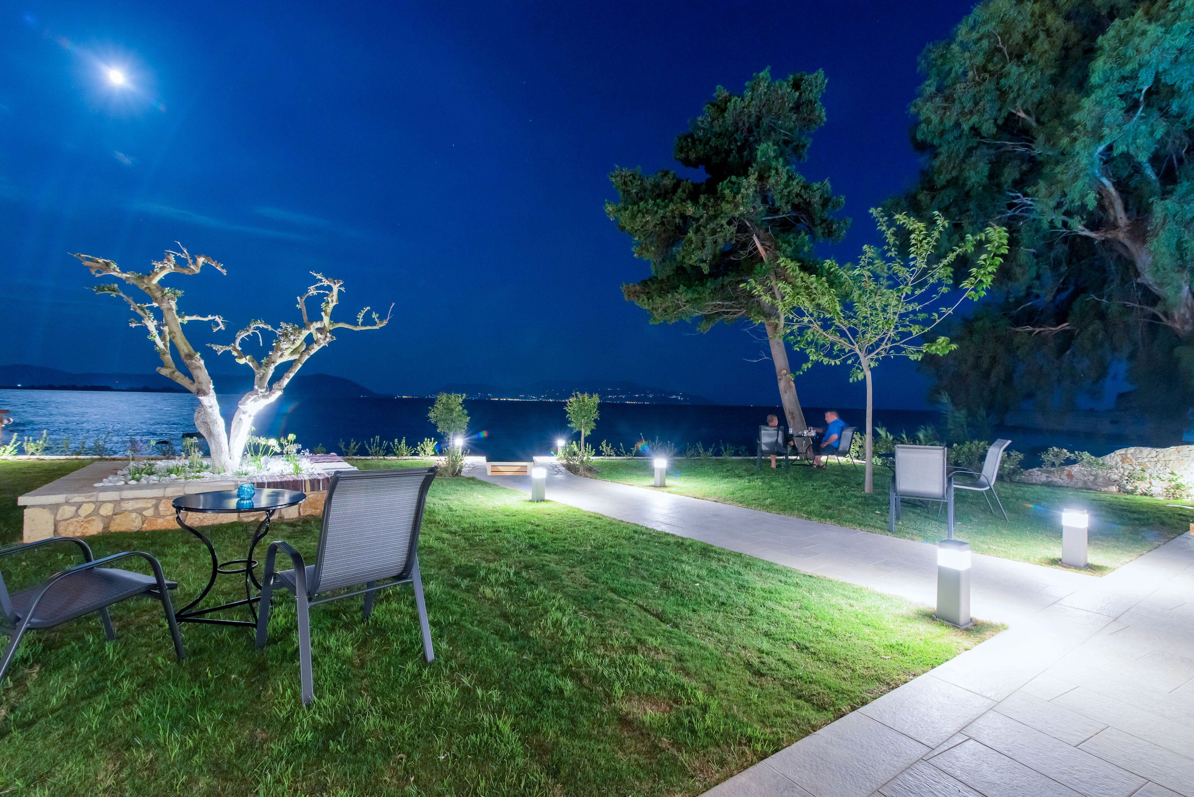 An outdoor seating area with a table and chairs, a pathway, and trees.