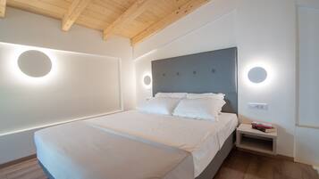 Un dormitorio moderno con una cama grande, luces de pared circulares y techo de madera.