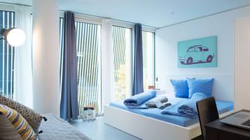 Een moderne slaapkamer met een bed, een bureau en een raam met gordijnen.