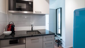 A modern kitchen with a built-in microwave, stainless steel sink, and a dish drying rack.