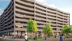 A multi-story parking garage with a curved facade, outdoor seating area, and trees. - Hitrental Basel Apartments (Basel)