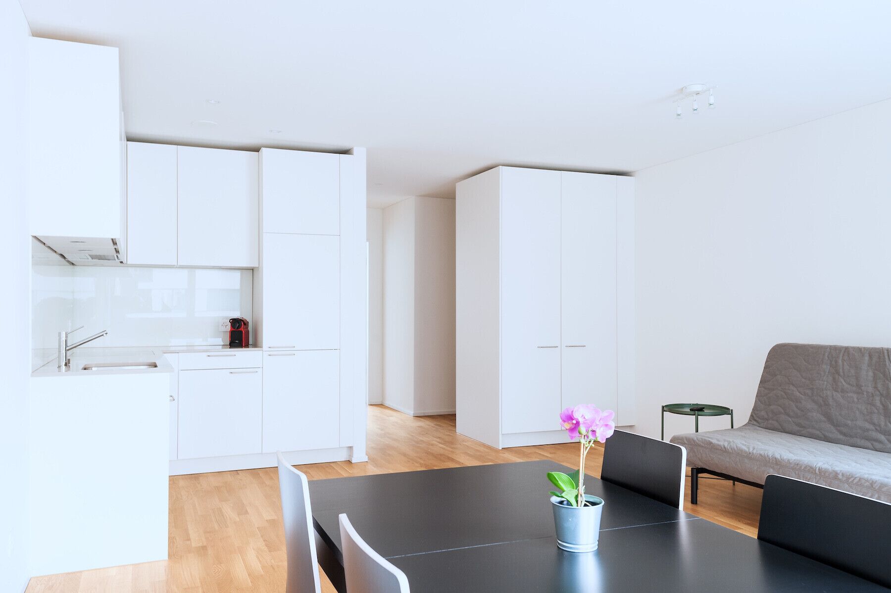 Un espai de viure modern i minimalista amb cuina, zona de menjador i saló.