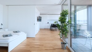 A modern apartment with a living area, kitchen, and balcony. - Hitrental Basel Apartments (Basel)