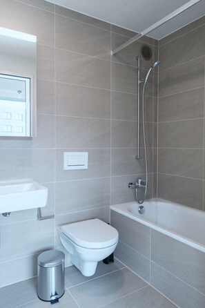 Un baño moderno con inodoro, bidé y bañera.
