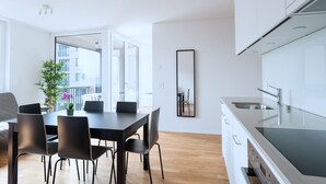 Eine moderne Küche mit weißen Schränken, einer Edelstahl-Spüle und einer schwarzen Arbeitsplatte.