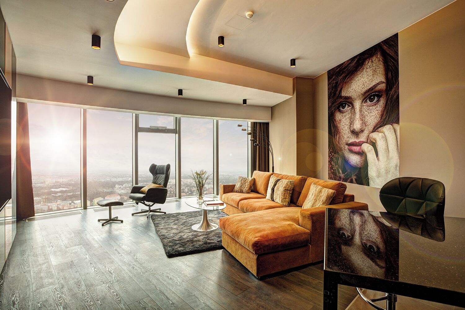 Una sala de estar moderna con un gran ventanal, un sofá, una mesa de centro y una silla.