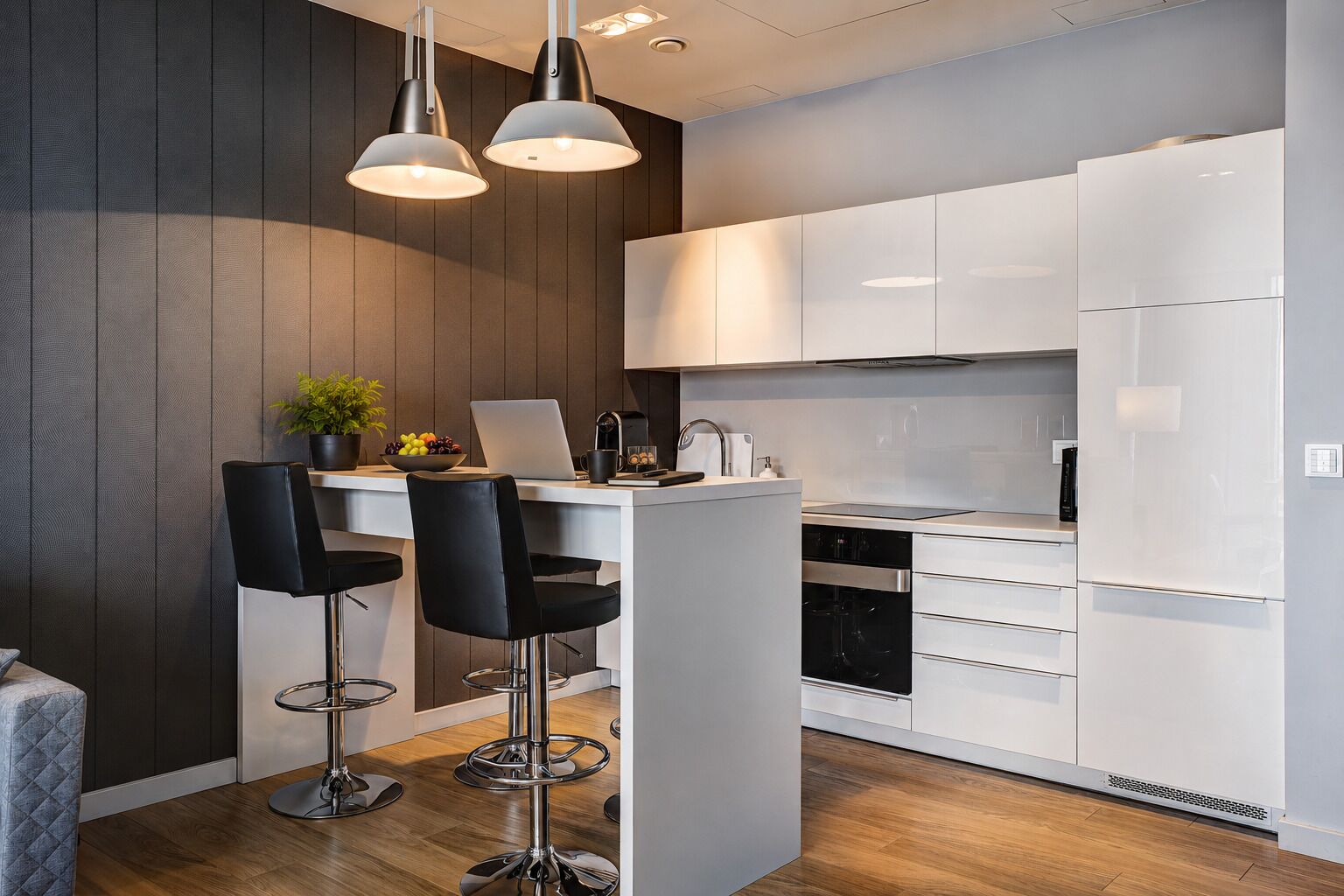 A modern kitchen with white cabinets, a central island with bar stools, and pendant lighting.