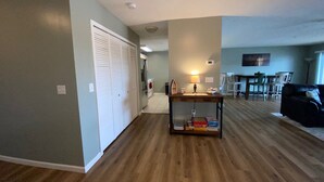 A spacious living room with a wooden floor, a dining area with a table and chairs, and a kitchen in the background. - Sunset On The Water! (Port Clinton)