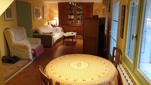 Una sala de estar acogedora con una mesa redonda, un sofá y una estantería.
