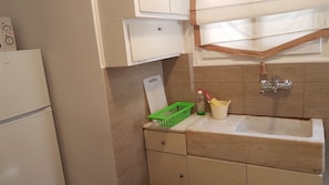 Kitchen area with a refrigerator, sink, and cabinet.