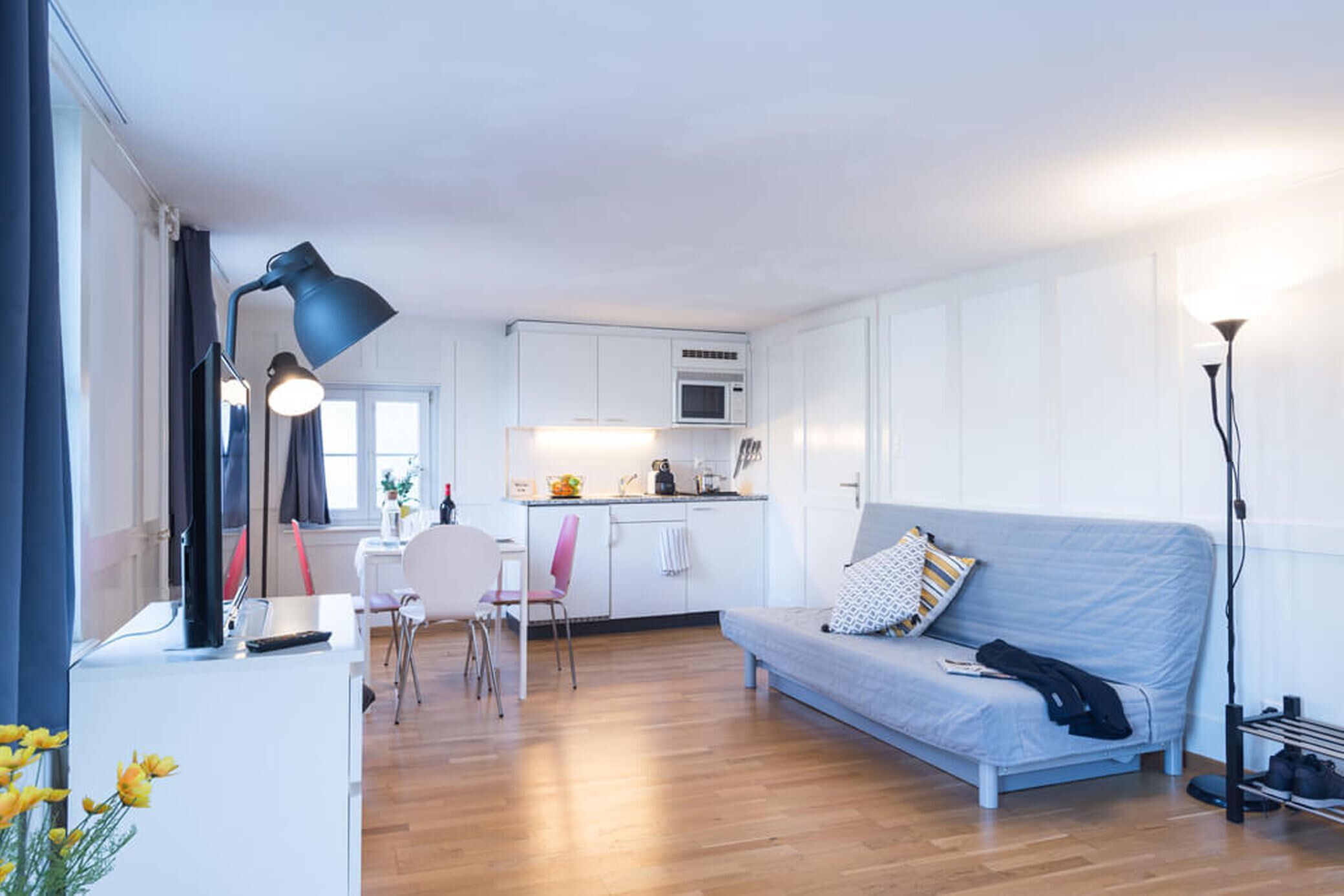Una sala de estar moderna con sofá, comedor y cocina.