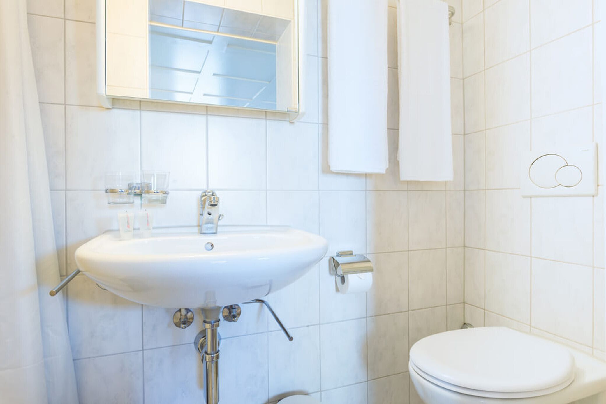 Ein Badezimmer mit Waschbecken, Spiegel und Toilette.