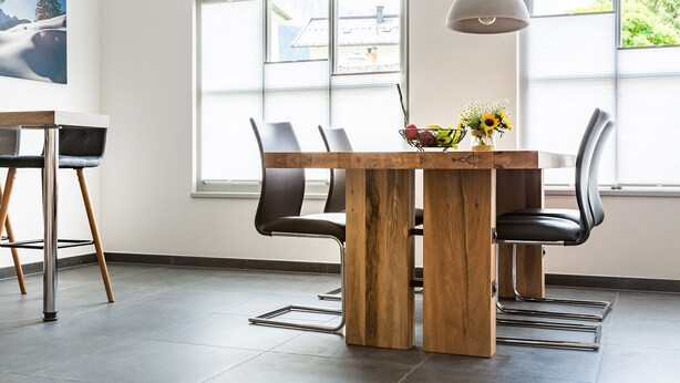 A modern dining area with a wooden table, black chairs, and a pendant light. - Exclusive vacation apartment in a unique location in the heart of Mittenwald. (Mittenwald)