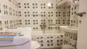 Bañera, toallas, shampoo, papel higiénico