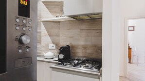 A modern kitchen with a stainless steel range hood, a coffee maker, and a kettle on the counter.