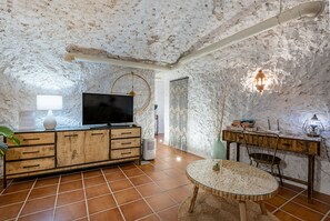 Relax in a cozy space with a flat-screen TV, round table, and comfortable chair.