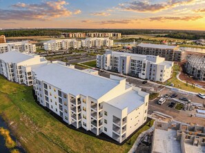 A modern apartment complex with multiple buildings, parking areas, and a construction site.