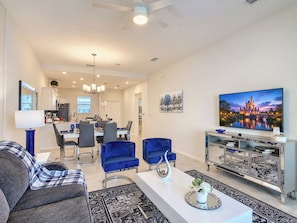 A modern living room with a sofa, chairs, a coffee table, and a television.