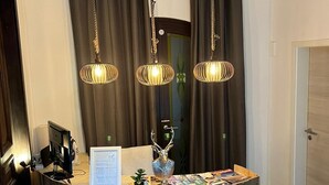 Un comptoir d’accueil avec un revêtement en bois, une petite plante, une tête de cerf décorative et un panneau d’accueil.