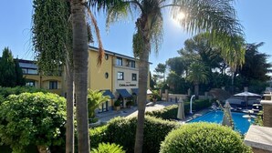 Un hotel con piscina, palmeras y jardines bien cuidados.