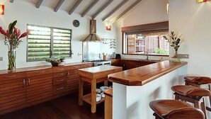 Een keuken met houten kastjes, een centraal kookeiland en een groot raam.