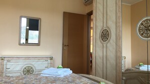 Een hotelkamer met een bed, een kledingkast en een spiegel.