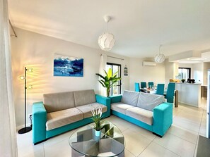 Relax in this stylish living room with a sofa, coffee table, and dining area.