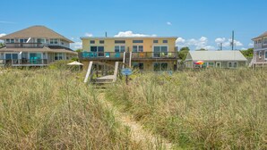 A beachfront property with a two-story building, a covered patio, and a visible beach access path. - Oceanfront | Spacious Deck | Beautiful Views | Seagate Condo (Fernandina Beach)