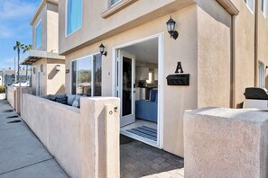 Welcome to a cozy home with a glass door entrance, outdoor seating area, and mailbox.