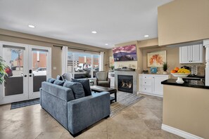 Relax in the living room with a fireplace, sofa, and armchair, and enjoy the view from the large window.