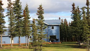A modern two-story building with a blue exterior and a covered patio area.
