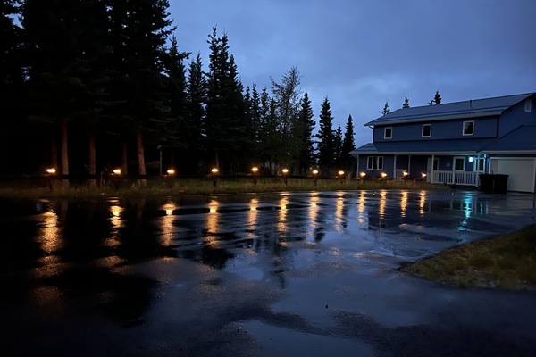 Outside lighting and the reflection on the wet asphalted driveway.