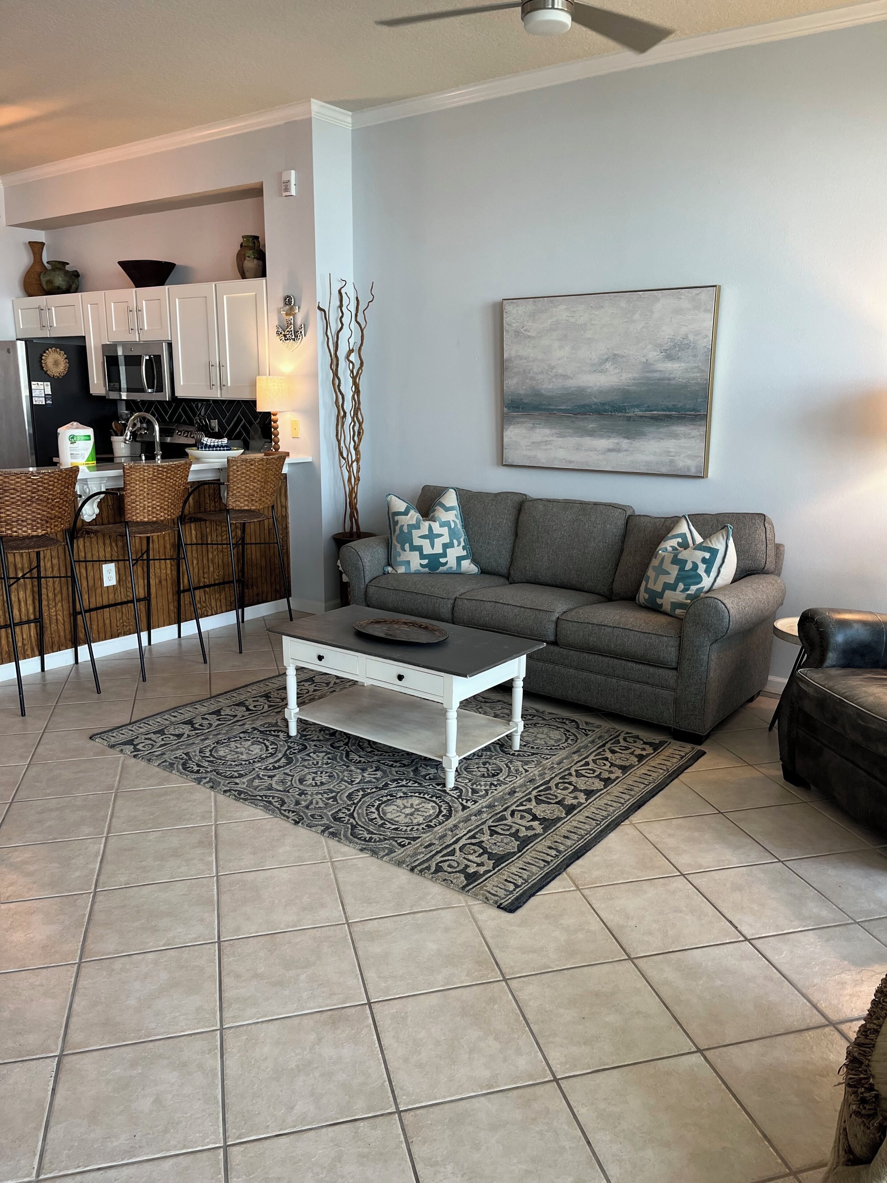 A living room with a gray sofa, patterned rug, and a coffee table.